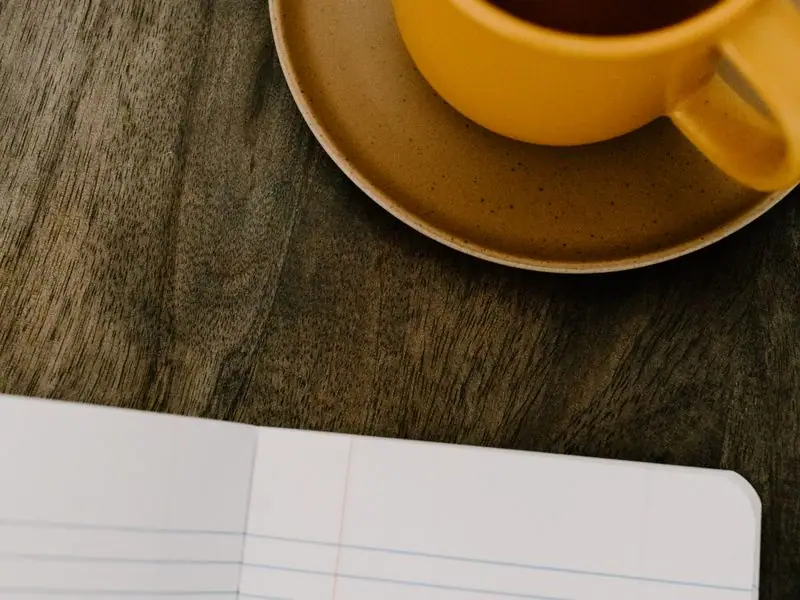 A cup of tea beside an open notebook