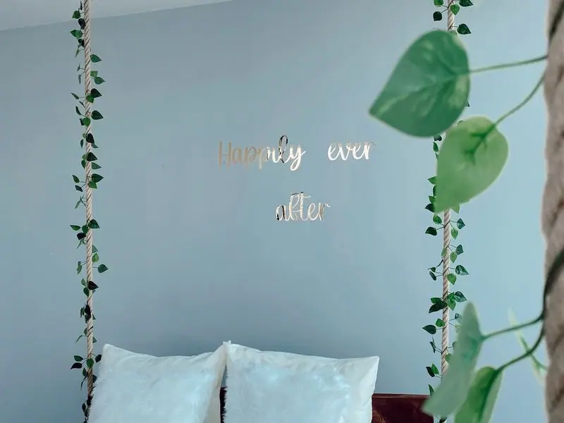 A serene guest room with linen bedding and a potted plant