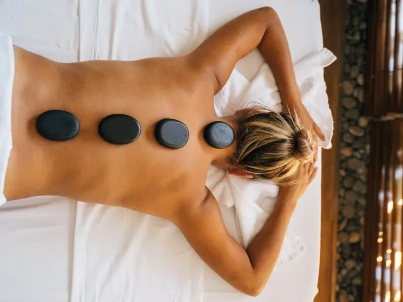 A warm-stone massage in progress on a treatment table